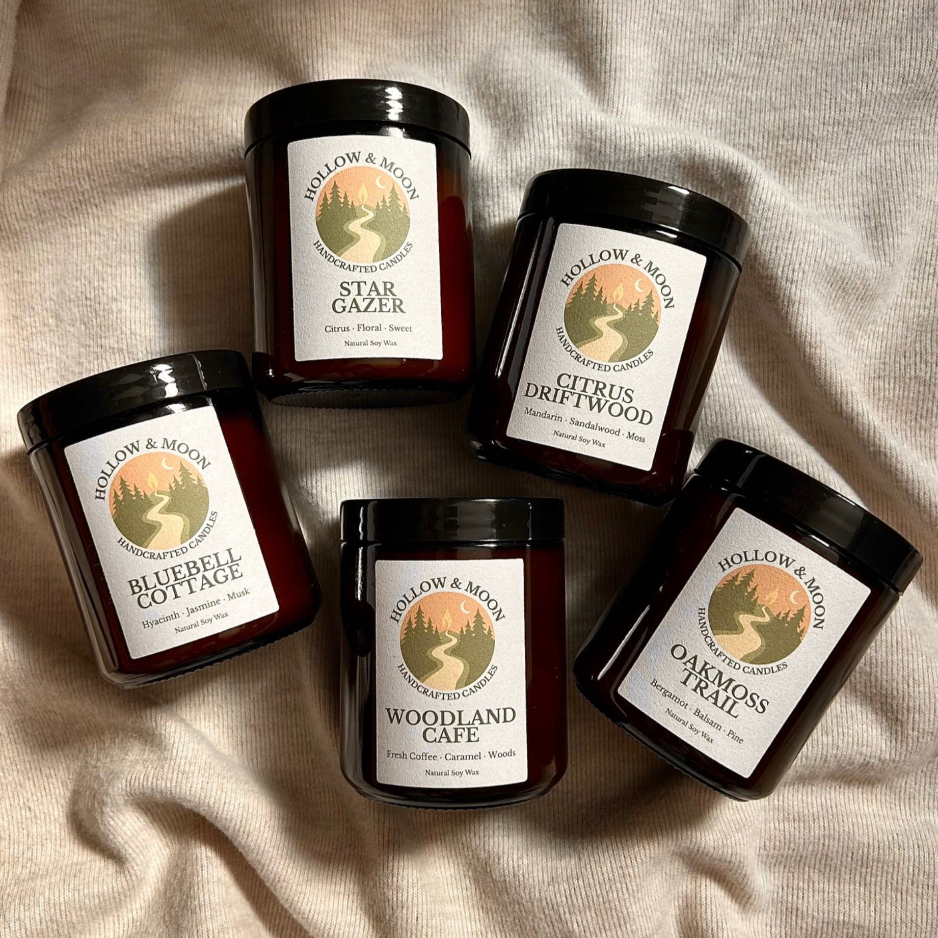 Five candles with labels on a beige fabric background
